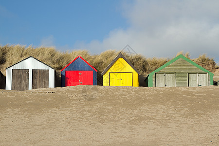 海滩小屋绿色黄色天空蓝色红色假期沙丘背景图片