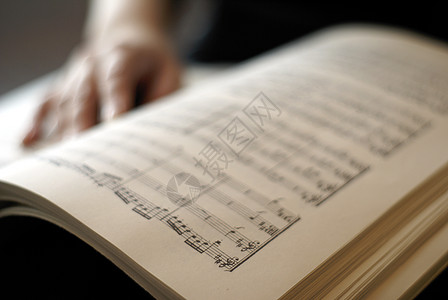 女性手在乐谱书页上歌词阅读歌曲线条分数图片