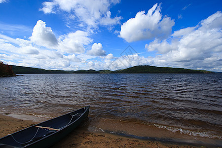 海滩上的独木舟蓝色进口波浪游泳皮艇旅行海岸假期支撑海洋图片