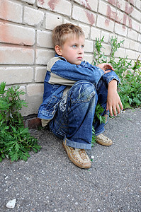 青年男子坐在对着涂鸦的旁边寂寞城市男孩们孤独衣服悲伤青少年孩子图片