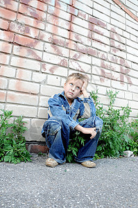 青年男子坐在对着涂鸦的旁边悲伤青少年孤独衣服孩子城市男孩们寂寞图片