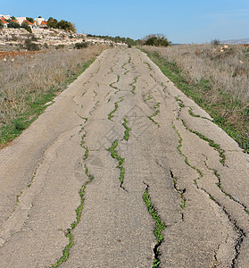 晚上的旧乡间道路破碎天空路线小路农村灌木丛地平线房屋沉降沥青蓝色图片