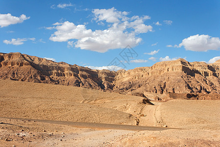 岩石沙漠中的道路橙子砂岩自然天空山脉丘陵地平线蓝色环境远足图片
