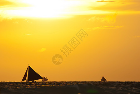 日落下海上的帆船海浪天空海岸旅游运动阳光假期反射橙子娱乐图片