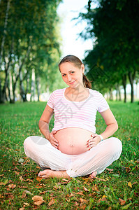 美丽的孕妇在公园里放松了一下怀孕女性森林树木母性父母瑜伽微笑生活女孩图片