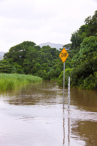 在澳大利亚昆士兰州采用深度指标的洪泛道路下雨倾盆大雨荒野危险路障交通激流沼泽街道风暴图片