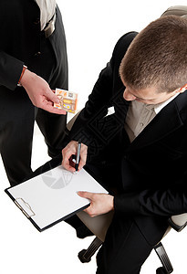 一名商务人士在签署合同时被收受贿赂的图片