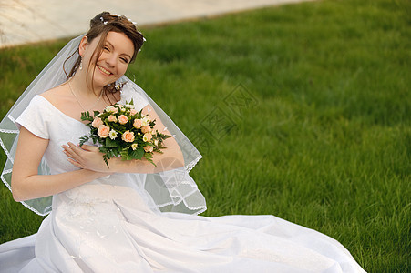 在草坪上的新娘婚礼裙子眼睛婚姻订婚花园庆典衣服头发花束图片