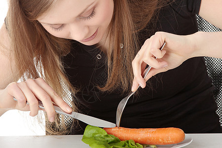 年轻女人吃盘子里的胡萝卜头发女性食物蔬菜女士午餐厨房微笑营养重量图片