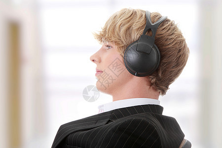 年轻商务人士用音乐放轻松耳机男人套装电子产品享受喜悦青年经理商务商业图片