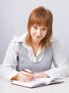 拿着笔记本的女孩管理人员商业人士蓝色记事本桌子办公室文档工作职场图片