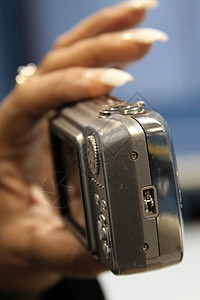 妇女手持数码相机美甲概念戒指手臂拍照镜片女性相机摄影师奢华图片