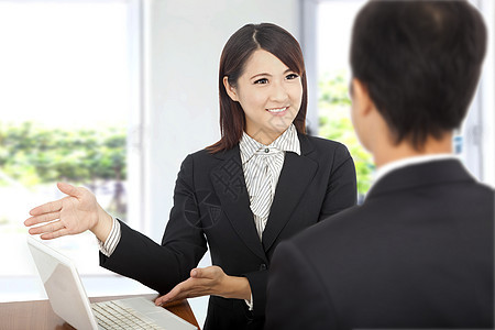 微笑着的女商务人士在笔记本电脑上露面 向客户解释工作计划图片