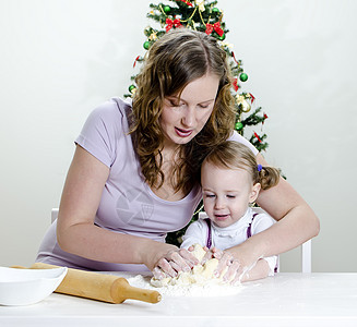 小女孩和妈妈正在准备圣诞饼干烹饪婴儿女士面包擀面杖家庭食物女性童年母亲图片