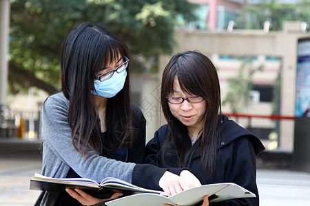 亚洲学生在大学学习和讨论的亚洲学生人数微笑家庭作业学校笔记本教育书柜知识朋友女性同学图片
