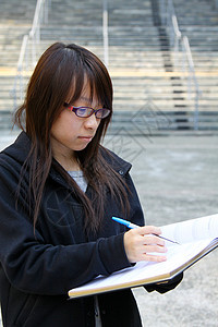 在大学学习的亚裔女孩微笑校园学生课堂知识公园笔记本学校图书馆房间图片