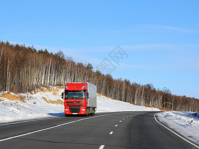 冬天路上的红色卡车蓝色货运旅行街道车辆速度货物轮子天空土地图片