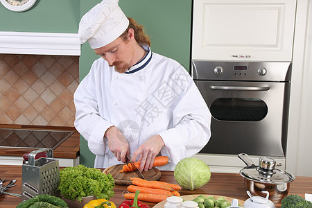 在厨房准备午餐的年轻厨师工人烹饪餐具白色餐厅衣服烤箱职业盘子男性图片