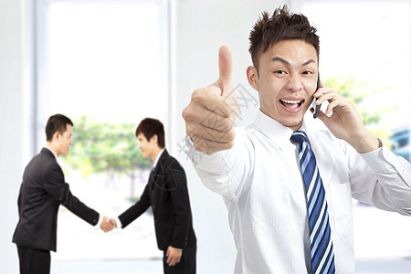 成功的商务人士在电话上 用拇指举起手图片