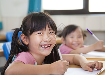 在课堂上快乐的孩子们教育青年桌子孩子微笑女性学习房间女孩班级图片