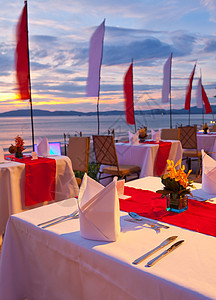 日落时吃晚饭餐厅家具派对假期海岸天空太阳饮料椅子用餐图片