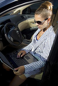 商业妇女使用笔记本电脑喜悦本科太阳镜人士情感工作技术享受大学游戏图片