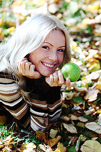 拥有绿苹果的妇女金发女郎女孩青少年季节食物乐趣女士橙子木头森林图片