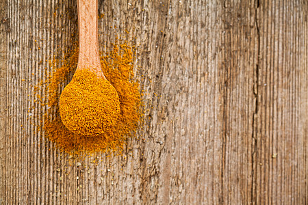 黄色粉末木勺中的咖喱粉种子美食香料粉末木头勺子厨房乡村草本植物烹饪背景