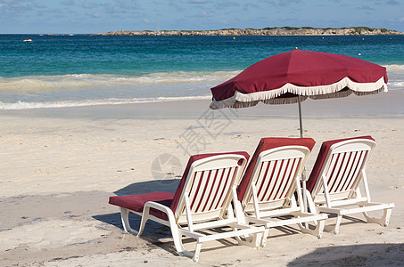 3个沙滩休闲游客和沙上雨伞塑料热带旅行天堂假期靠垫座位三重奏太阳明信片图片