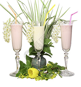 玻璃杯 带有奶制品鸡尾酒和白色背景 绿叶和青草的管子黄色树叶郁金香粉色绿色酒杯图片