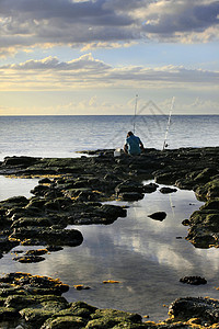 岸边的渔夫天空海洋地平线反射日落男生太阳闲暇假期爱好图片