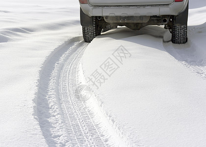 在一辆无法辨认的汽车后面的寒冬雪小路地平线牵引力驾驶警告车辆天空街道路线蓝色太阳图片