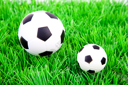 一个大球和一个小足球球 在塑料草上图片