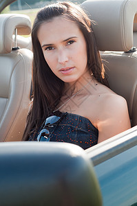 坐在车里的美丽的棕发美女女人图片