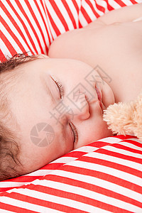 睡着的可爱小宝宝 在红色和白条纹枕头上儿子婴儿男生皮肤女孩新生女儿生活就寝说谎图片