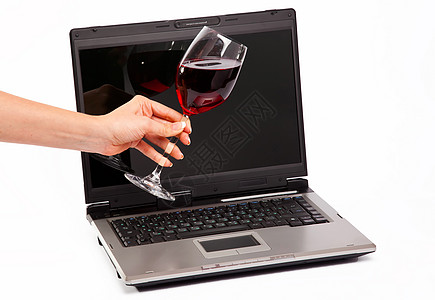 手提电脑和杯红酒图片