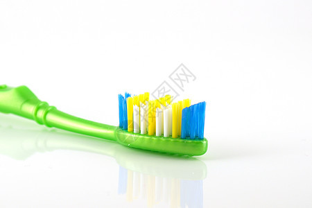 绿色手柄的牙刷卫生蓝色卫生员塑料美丽牙医假牙白色牙膏反射图片