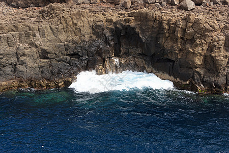 海岩正在冲破强大的波浪太阳气泡地平线海洋风暴岩石运动碰撞支撑石头图片