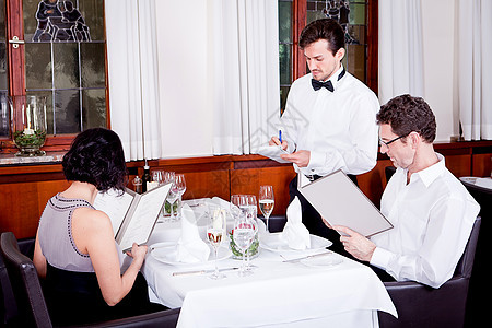 男人和女人在餐厅吃晚饭卡片服务员订购成人微笑酒店女性女士咖啡店幸福图片