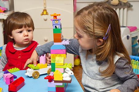 女孩玩砖头的小女孩逻辑生长孩子建筑婴儿专注头发喜悦活动玩具图片