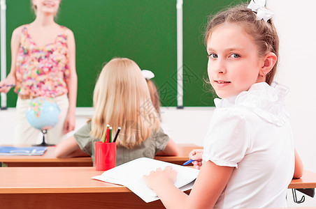 课堂上女孩的肖像成年人衣服孩子注意力黑板老师教育服饰班级数学图片