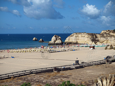 葡萄牙阿尔加韦Portimao的海滩蓝色遮阳伞海岸线太阳晴天孤独悬崖海洋娱乐反射图片