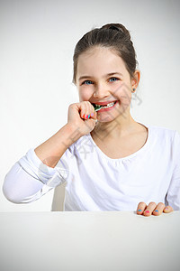 女孩在吃糖果 却被孤立在白边上图片