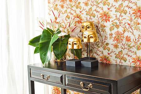 配有鲜花和室内装饰的侧桌餐具柜桌子房间金子墙纸窗帘橙子花朵面具设计师图片