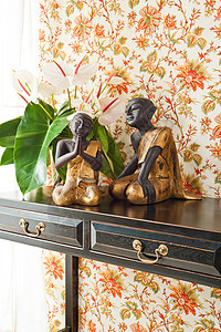 配有鲜花和室内装饰的侧桌房间窗帘花朵织物桌子公寓金子木头墙纸设计师图片