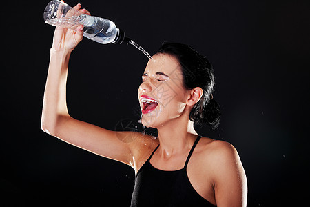 运动妇女用水冷却自己口渴工作室头发女孩身体液体瓶子女性矿物天气图片