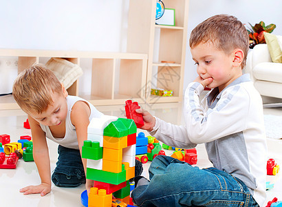 男孩在地板上打建筑布设的游戏儿童图片