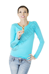 年青妇女吃谷物糖棒甜点小麦早餐谷物食物玉米饲料小吃活力糖果图片