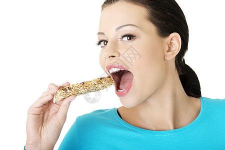 年青妇女吃谷物糖棒饥饿早餐小麦谷物燕麦粮食糖果饮食女孩营养图片