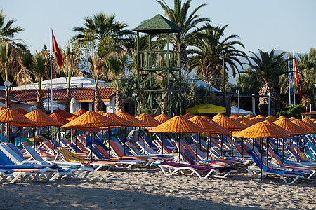 海滩休息员和海边的雨伞情调支撑闲暇天空休息海景阳伞橙子天堂旅游图片